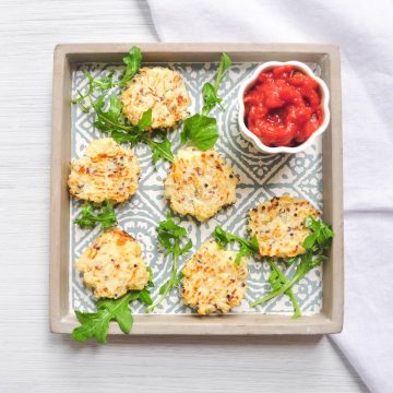 cauliflower cheese quinoa bites on tray with tomato dip