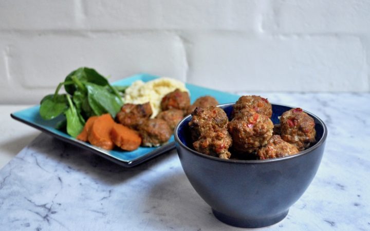 bowl of lamb meatballs with plate of meatballs with sweet potato and spinach behind