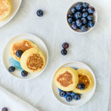 drop scones on two plates served with blueberries