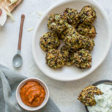 garlic mushroom quinoa bites in bowl served with roast vegetable dip and tzatziki