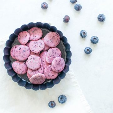 blueberry yogurt drops in circular dish with blueberries scattered around