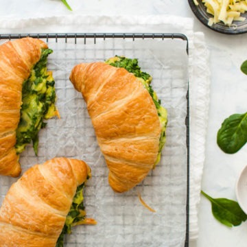 three spinach and cheese croissants on cooling tray