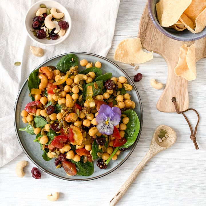 blue plate filled with Indian spiced chickpea salad with mini popadoms to the right