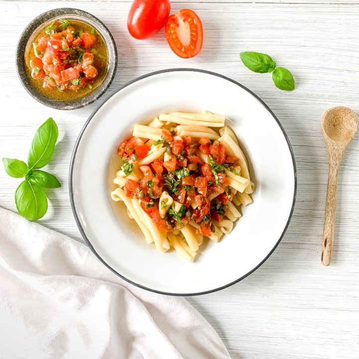 sauce vierge served on pasta in white bowl with more sauce to the top left