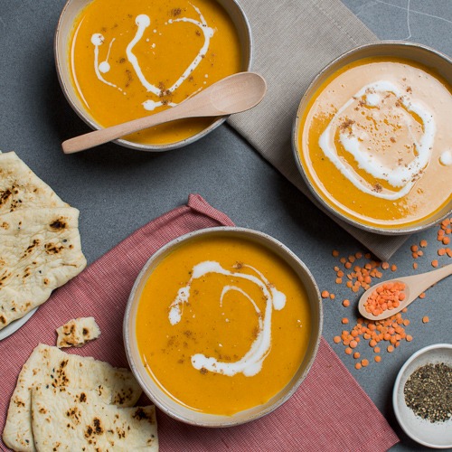 Three bowls of Mulligatawny soup with flat bread