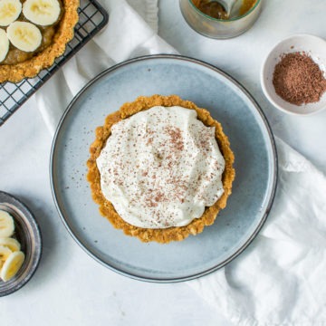 easy banoffee pie in centre of picture with half made pie on cooling rack to the left