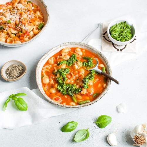Bowl of ministrone soup with basil leaves