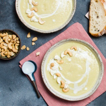 Bowl of spiced cauliflower soup decorated with nuts