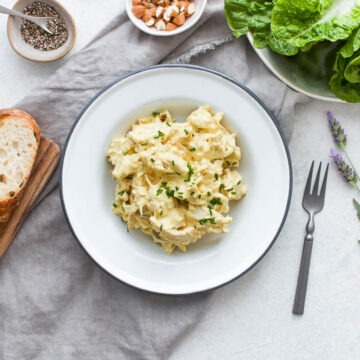 coronation chicken salad in bowl with lettuce and bread slices and extra black pepper ready to eat