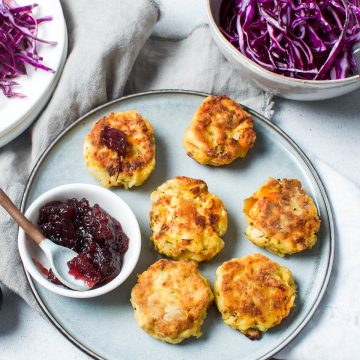 leftover turkey potato cakes on blue plate, served with red cabbage salad and cranberry sauce