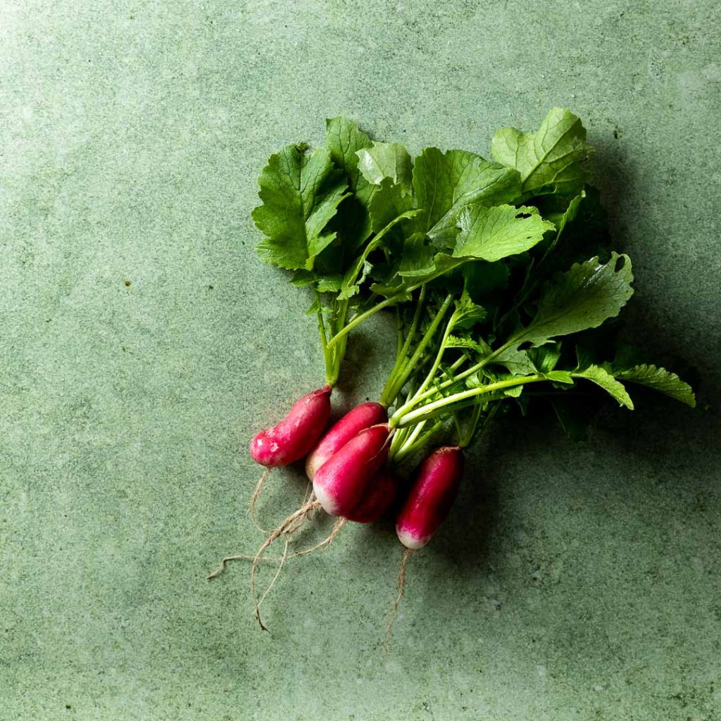 a bunch of radishes on green background