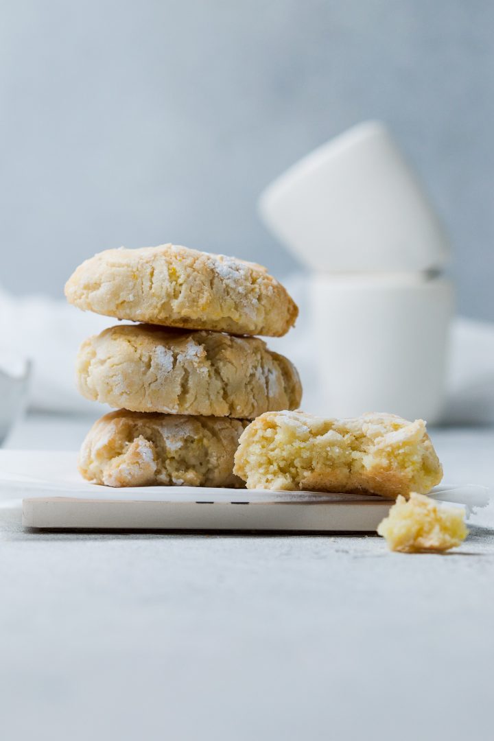 stack of three Italian Ricciarelli cookies with one to the right bitten into to show the soft centre