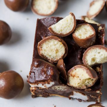 close up overhead photo of Malteser rocky road topped with Maltesers and the chocolate balls scattered around the plate