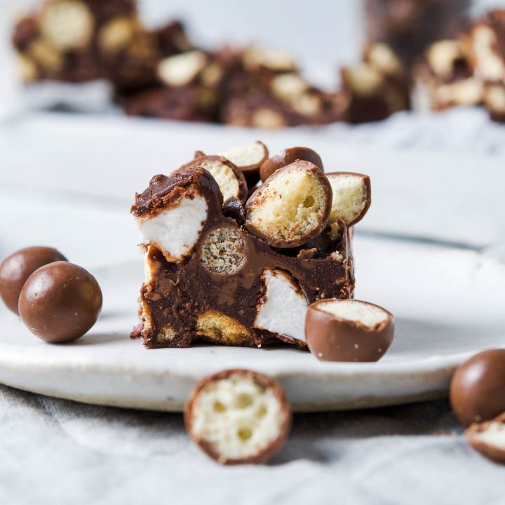 close up of a slice of Maltesers rocky road, to see the chunks of Maltesers, marshmallows and biscuit in the chocolate slice