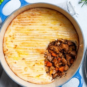leftover lamb shepherds pie in baking dish with a section of potato taken off to show the juicy lamb layer underneath