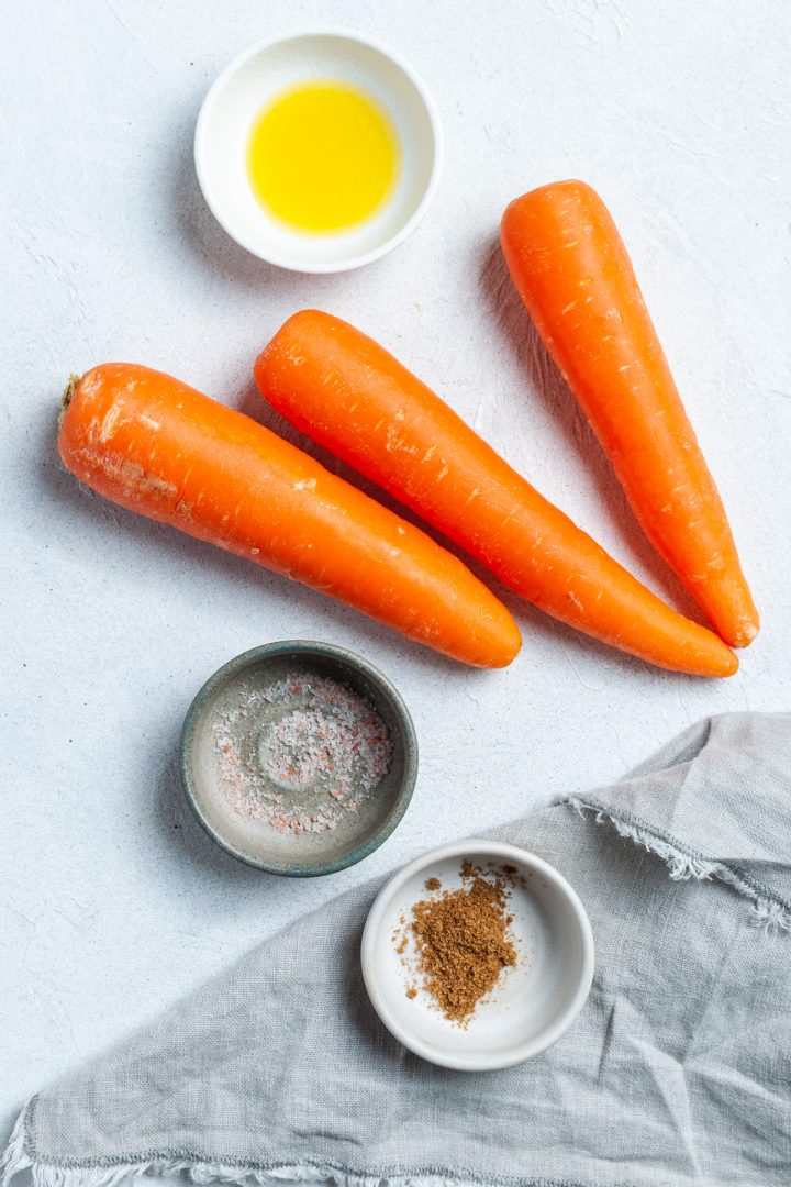 Ingredients needed laid out separately: 3 carrots, oil, sea salt and ground cumin 