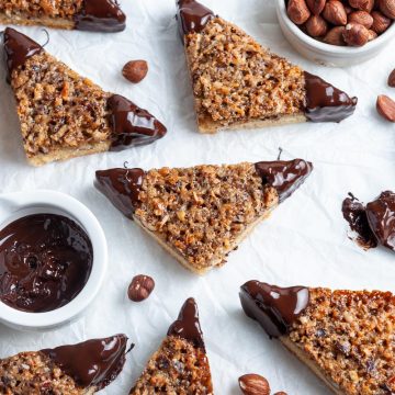 overhead shot of German nussecken on white background, freshly dipped in chocolate, the tips of the triangles glinting in the light