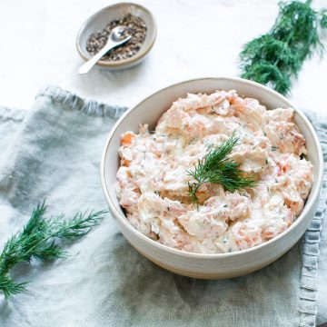angled overhead photo of smoked salmon pate in a bowl, topped with fresh dill