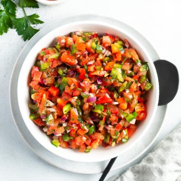 white bowl of Turkish salsa with a black spoon on the side ready to serve