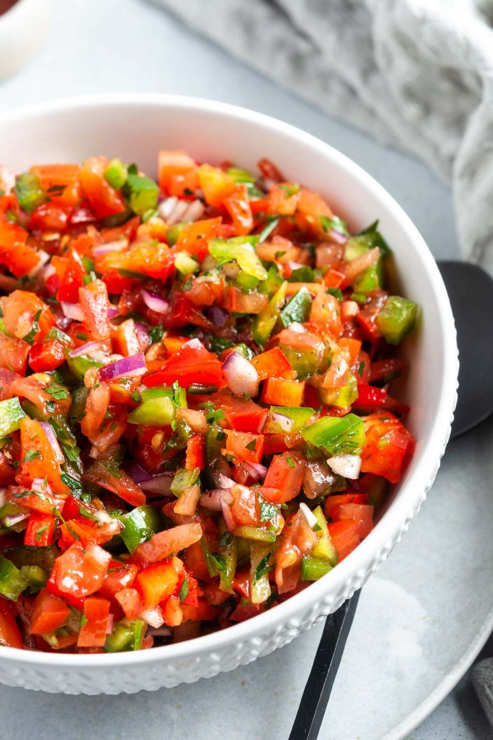 side view of Turkish salsa in a white bowl, to show the chopped vegetables and dressing