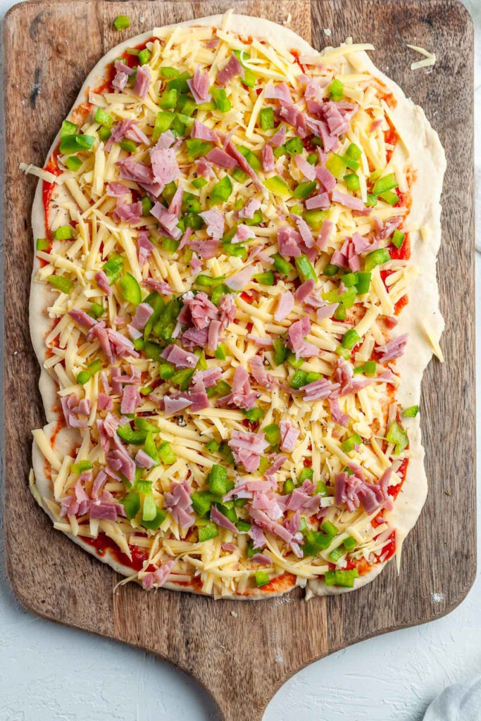 The toppings sprinkled over the rolled out dough.