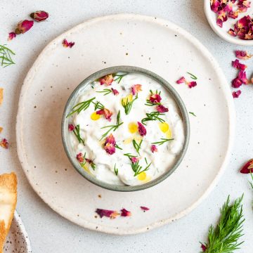 mast o Khiar in a bowl ready to eat, decorated with olive oil, edible rose petals and fresh dill