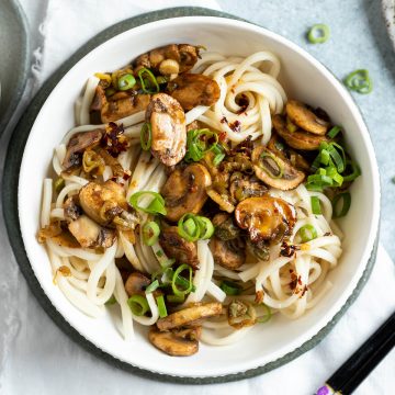 close up overhead of mushroom noodles in white bowl ready to eat