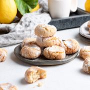 a blue plate of lemon almond cookies, with fresh lemons just visible in the background.