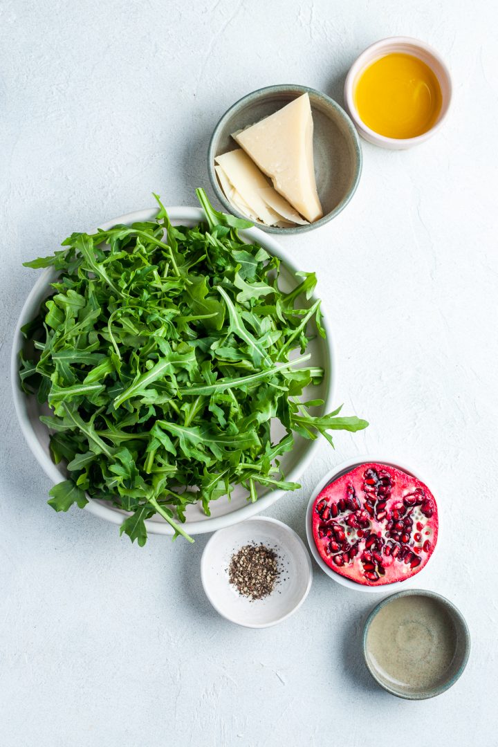 ingredients for rocket pomegranate salad measured out and arranged in individual bowls