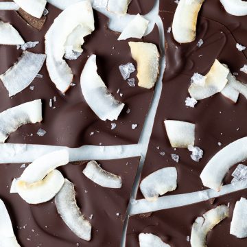 Close up overhead shot of dark chocolate bark to show the coconut shavings and flakes of sea salt