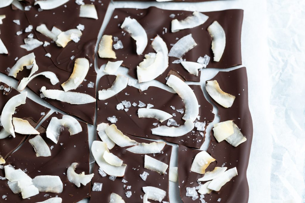 overhead close up of coconut chocolate bark, white greaseproof paper just visible behind