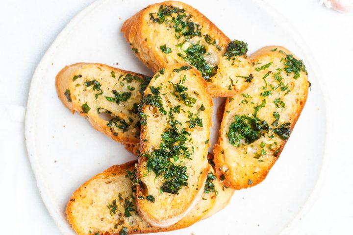 close up overhead of slices of air fryer garlic bread on a white plate