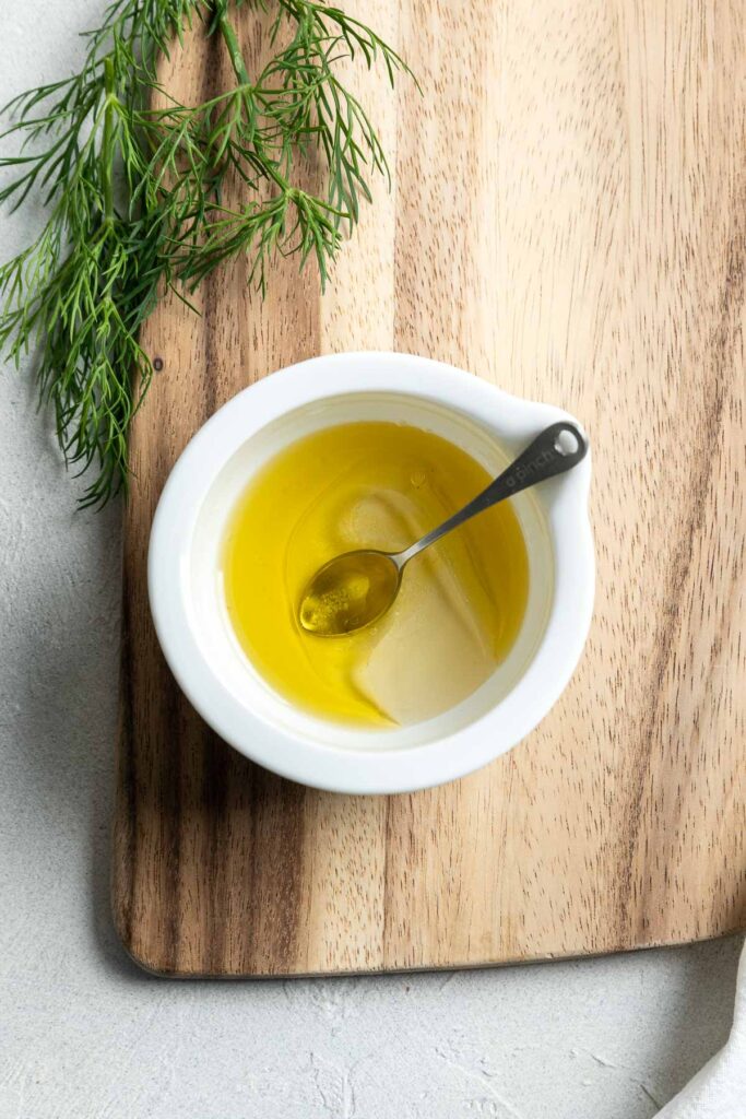 A small bowl of salad dressing with a spoon in it.