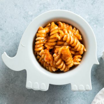 cooked pasta in vegetable lentil sauce served in a baby elephant bowl