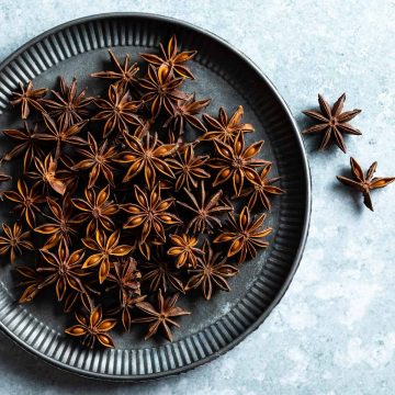 star anise on metal plate, with a couple to the right of the plate