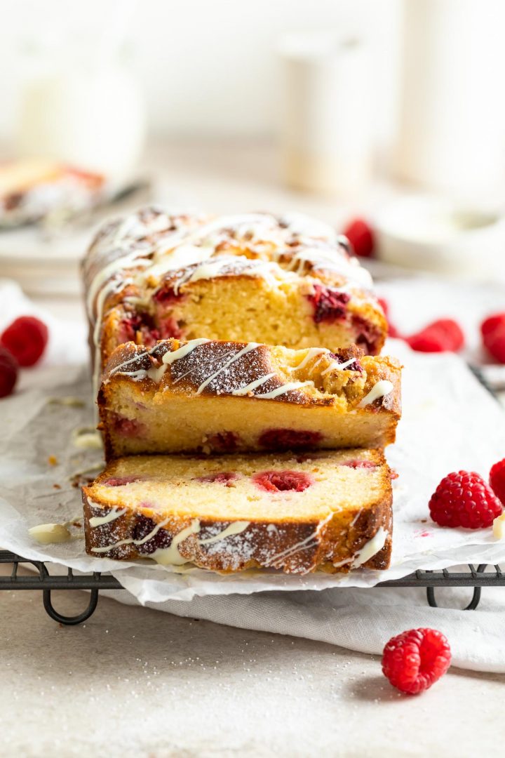 front view of chopped slices of loaf cake to show the distribution of raspberries throughout the cake