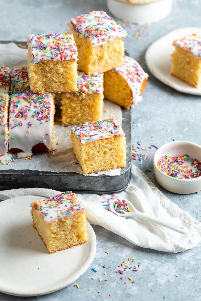 squares of iced sponge cake arranged to show the soft and light sponge 