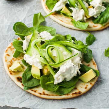 two chicken naan bread ready to serve on white baking paper