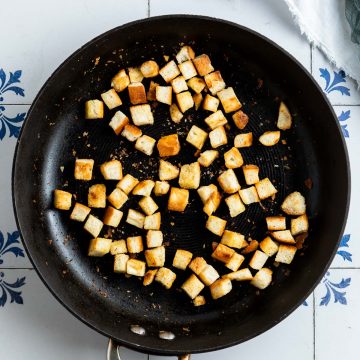 cooked golden homemade croutons in a frying pan