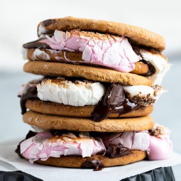 a close up of a stack of s'mores with melted chocolate and marshmallow dripping down the sides