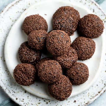 a white plate piled with brigadeiro ready to eat