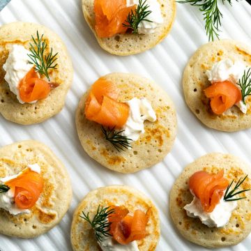 smoked salmon blinis on a white serving platter