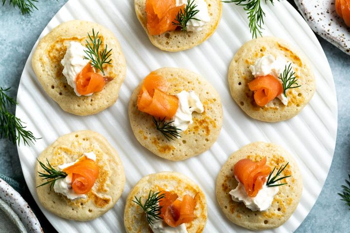smoked salmon blinis on a white serving platter