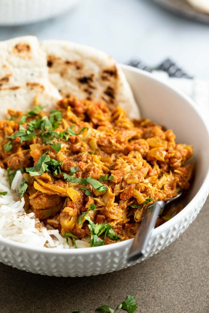 close up of leftover chicken curry served with naan breads