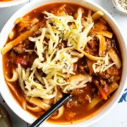 lasagna soup served in a white bowl topped with grated cheese.