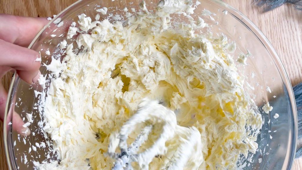 close up of whisked cream cheese in a bowl
