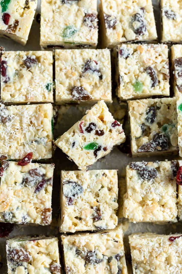 Close up of white Christmas squares, one on its side in the centre to show the glace cherries and other colourful dried fruit