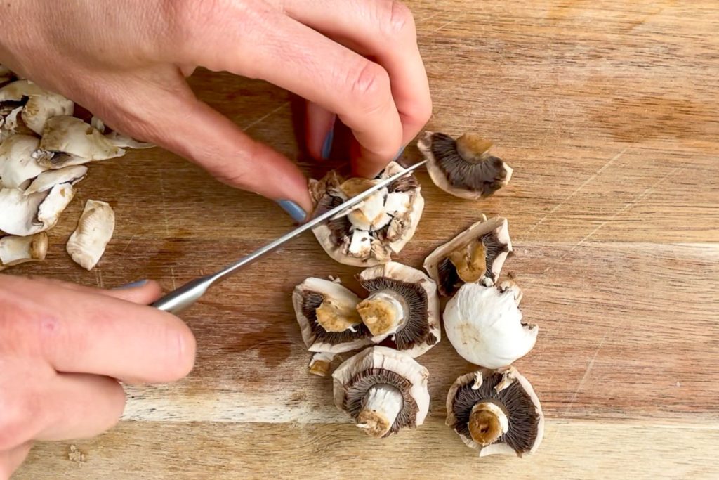 chopping peeled mushrooms into halves