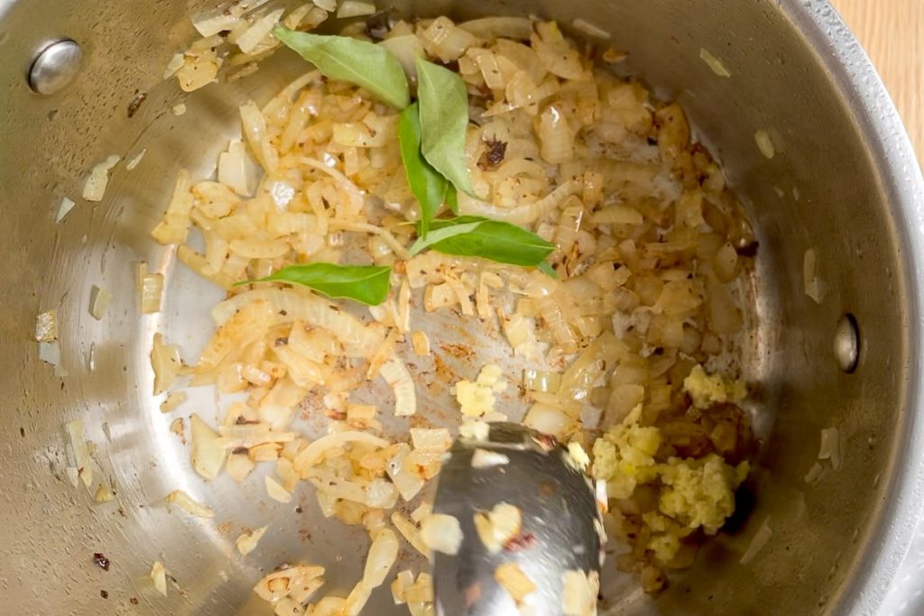 the curry leaves added to the cooked onion in the saucepan