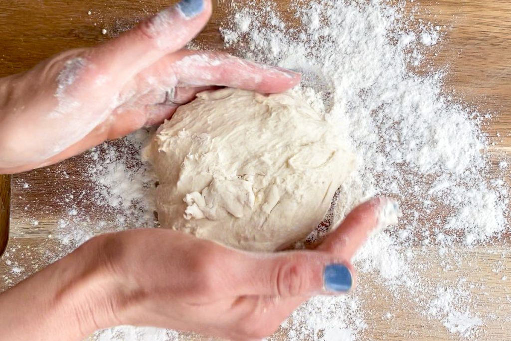 shaping the dough in to a round on a floured board